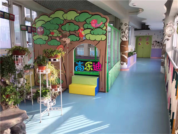 森林主题风格的蹦床旁，经营者放置了几盆绿植，对室内儿童乐园起到了巧妙的点缀作用。